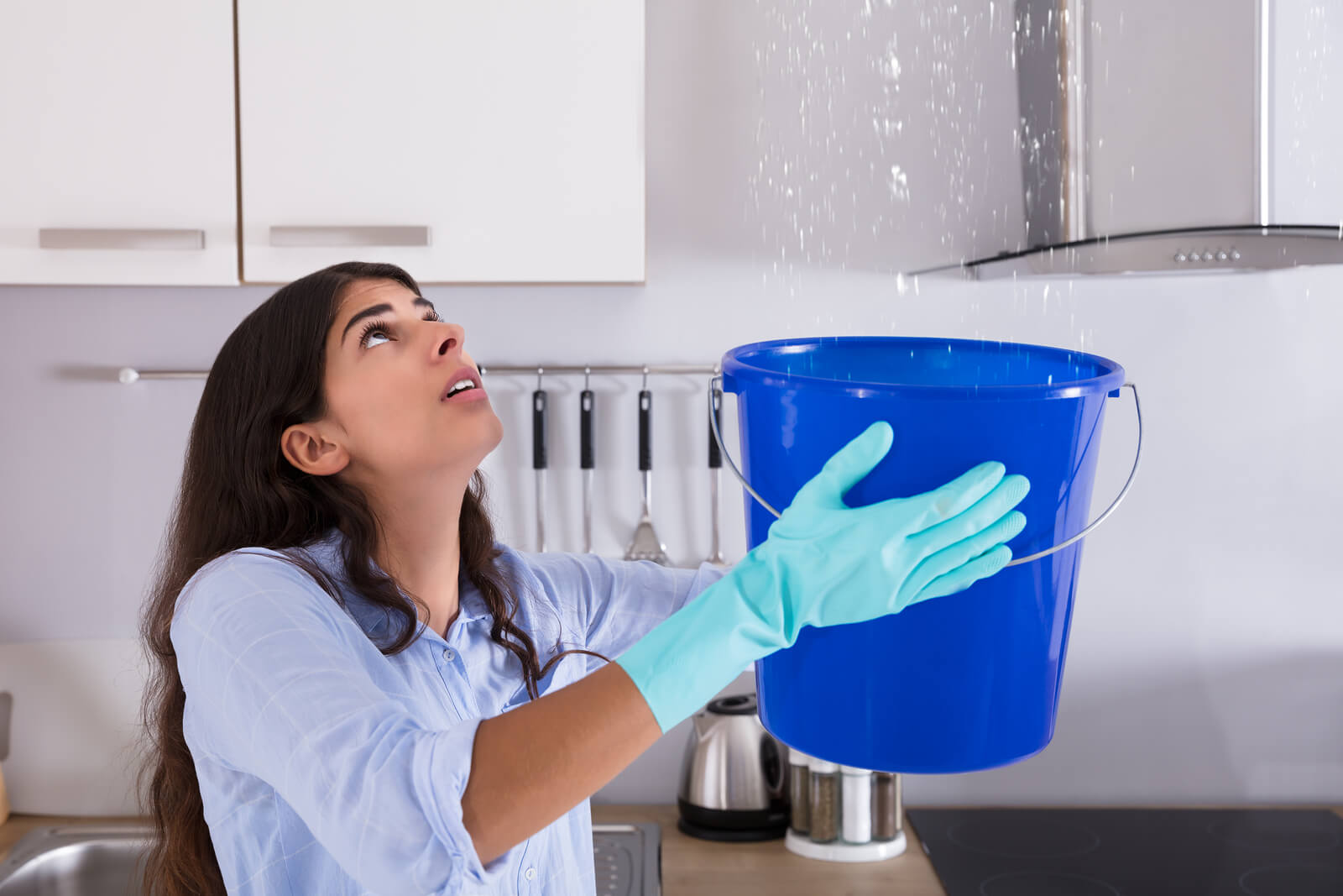 woman holding a bucket for leak