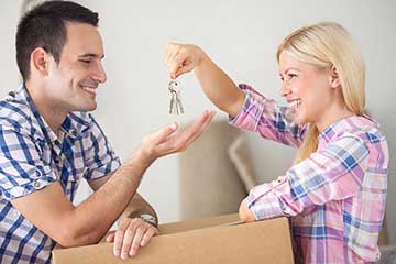 A woman handing a man a set of keys