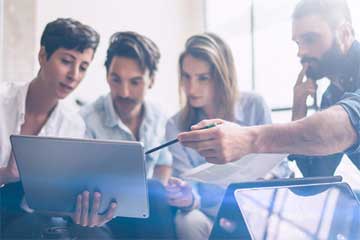 Four people looking at a laptop