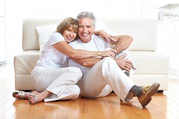 An older couple sat on the floor embracing