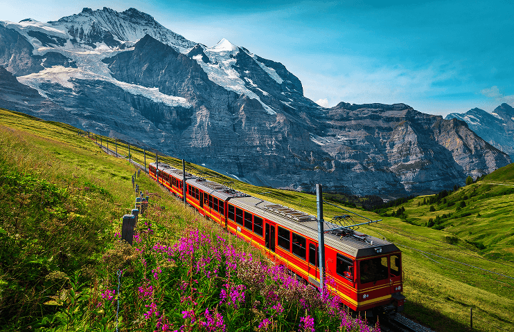 Image of a moving train with a Swiss mountain in the backgroud