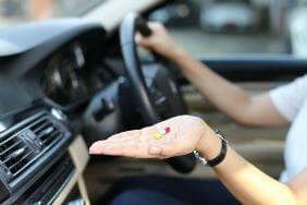 A person holding two tablets whilst sat in a car