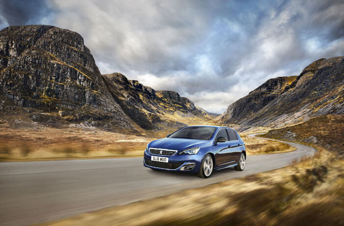 blue peugeot 308 driving on country road