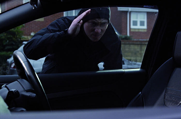 Thief trying to break into a car